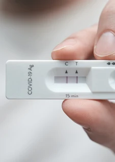 En hand som visar upp ett positivt coronatest.