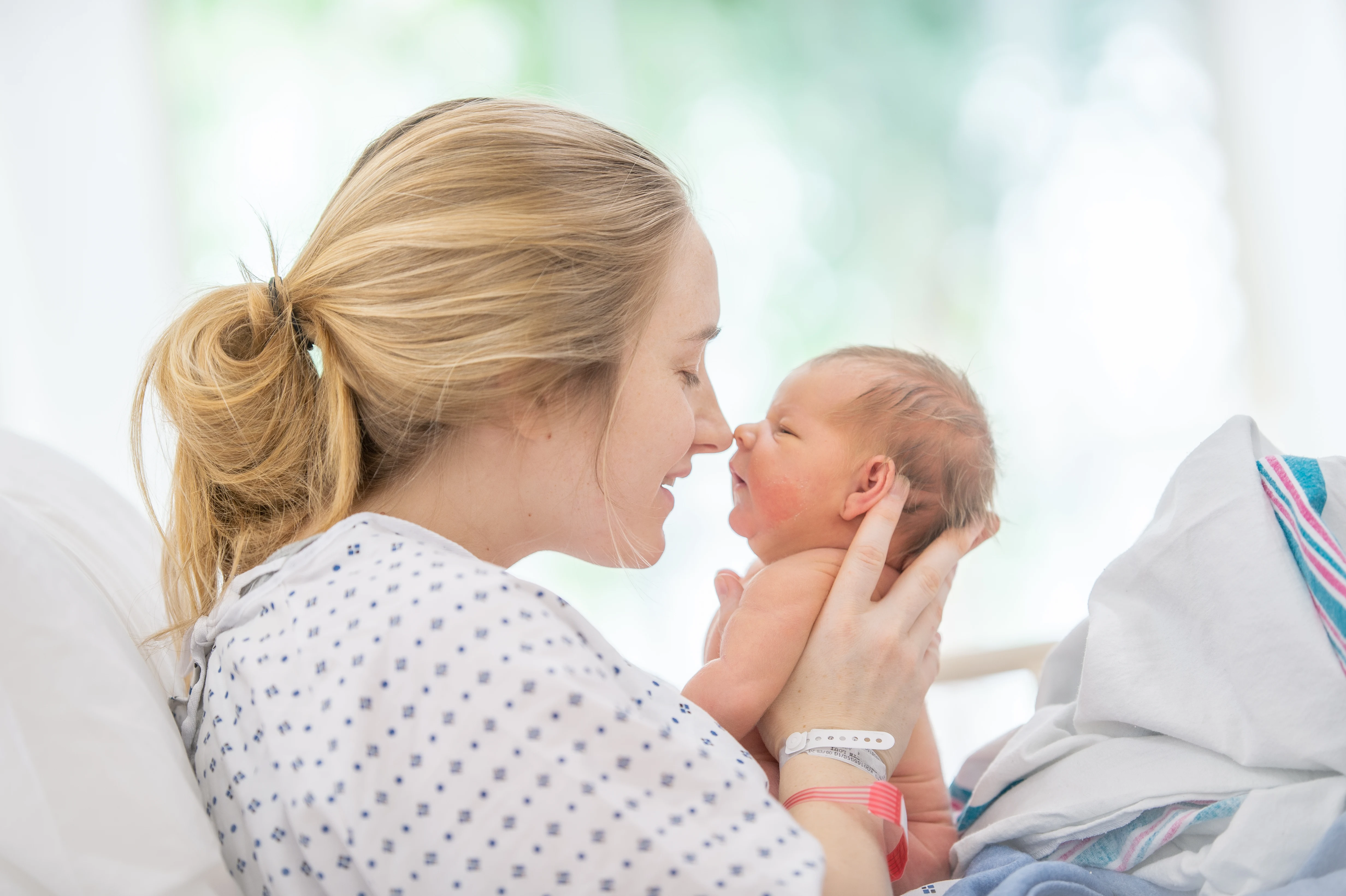 Mamma och nyfödd som bondar på bb.