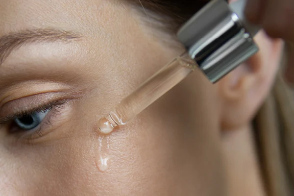 En kvinna applicerar serum. 