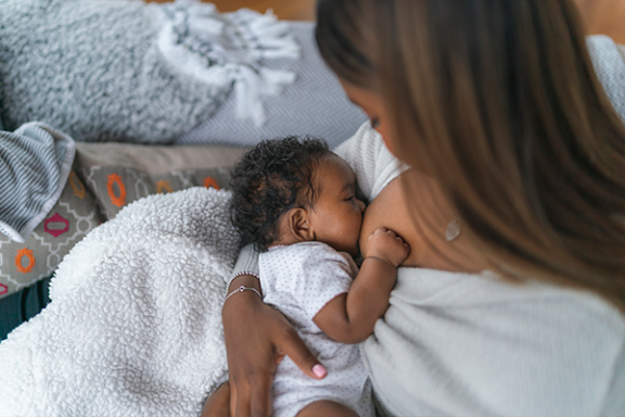 Mamma som ammar bebis med mjölkallergi.