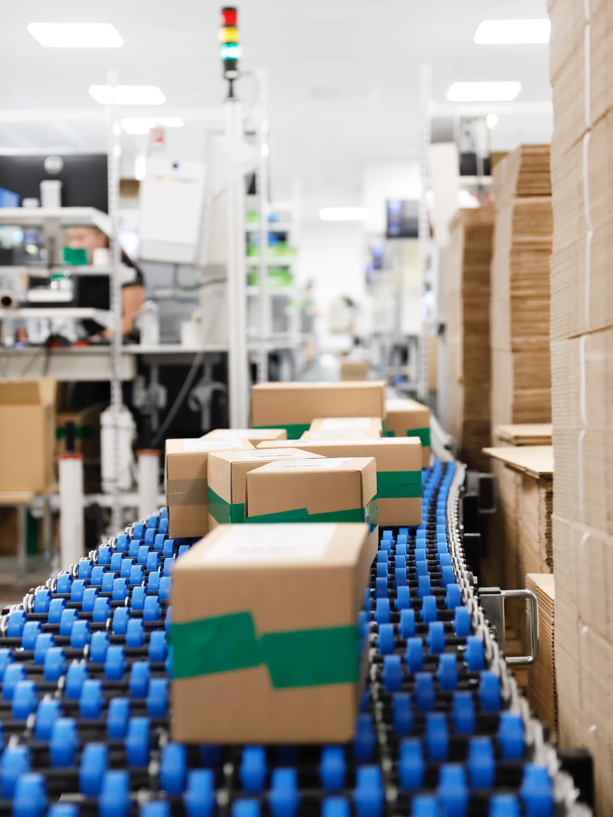 Paketlådor som forslas på ett band i ett lager