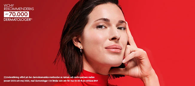 En kvinna som håller handen på sitt ansikte mot en röd bakgrund och texten Vichy rekommenderat av 70 000 dermatologer uppe i vänstra hörnet.