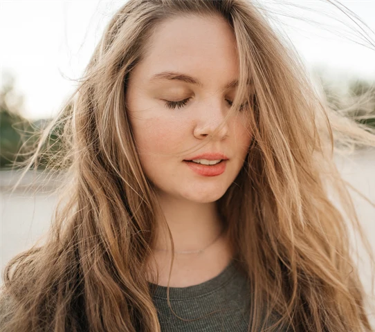 En ung kvinna utomhus en sommarkväll.