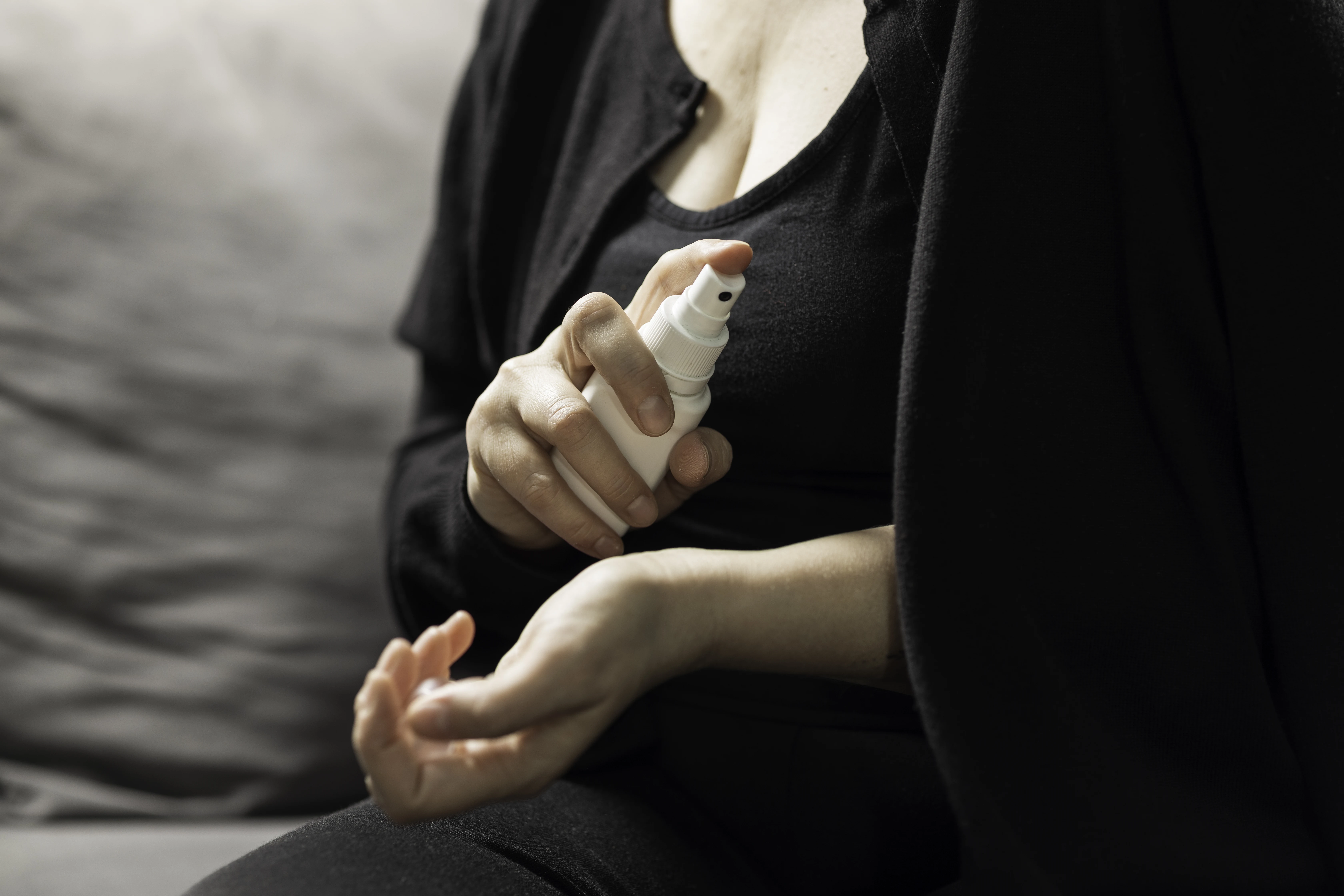 Kvinna i klimakteriet som användar hormonläkemedel i sprayform på handleden för att dämpa sina klimakteriebesvär.
