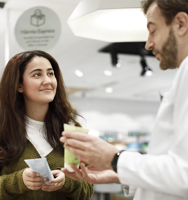 En kund och farmaceut i ett apotek. 