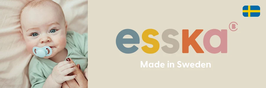 En bebis med en napp i munnen. Text på bild lyder: esska- Made in Sweden.