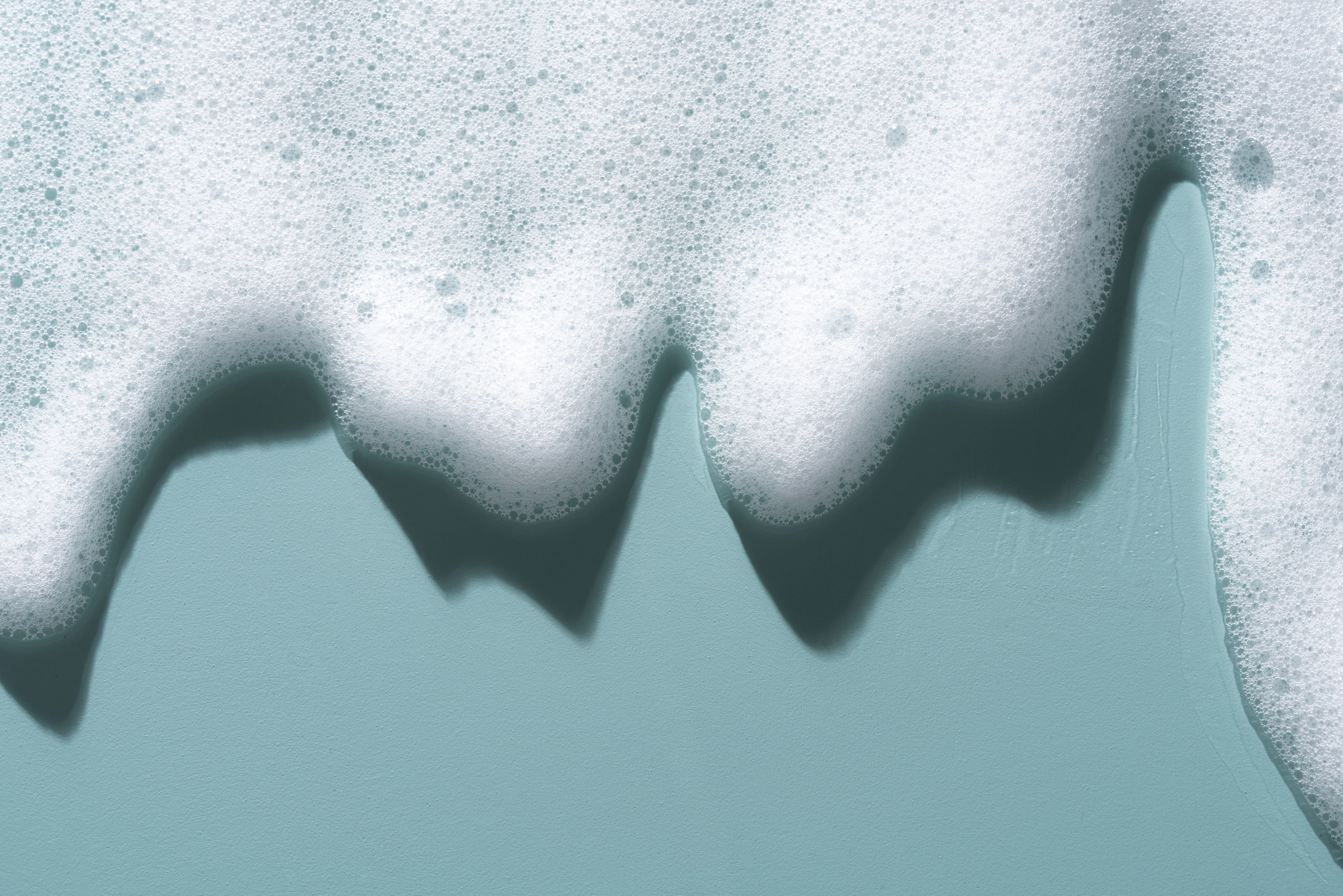 Skum som rinner ned från en blå bakgrund.