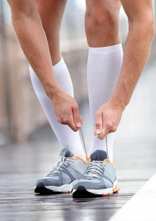 Man som har på sig stödstrumpor på löprundan.