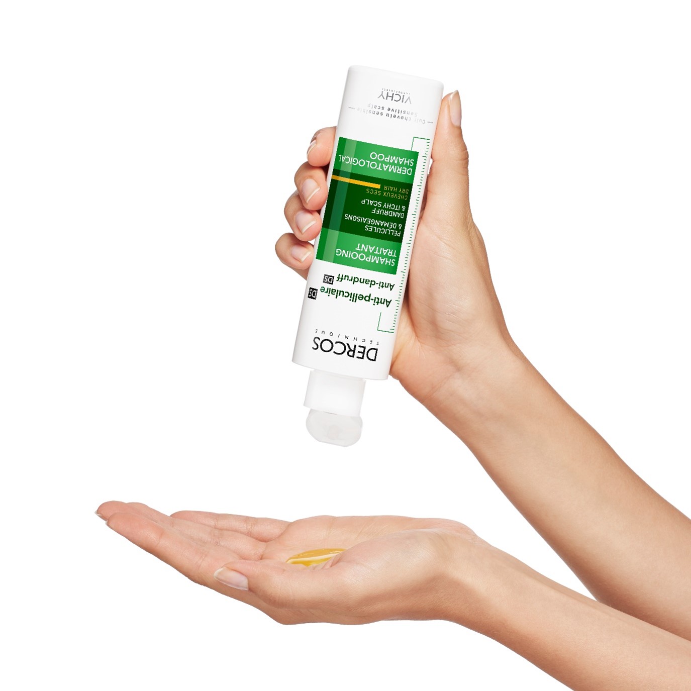 Händer som håller i en Vichy Dercos mjällschampo.