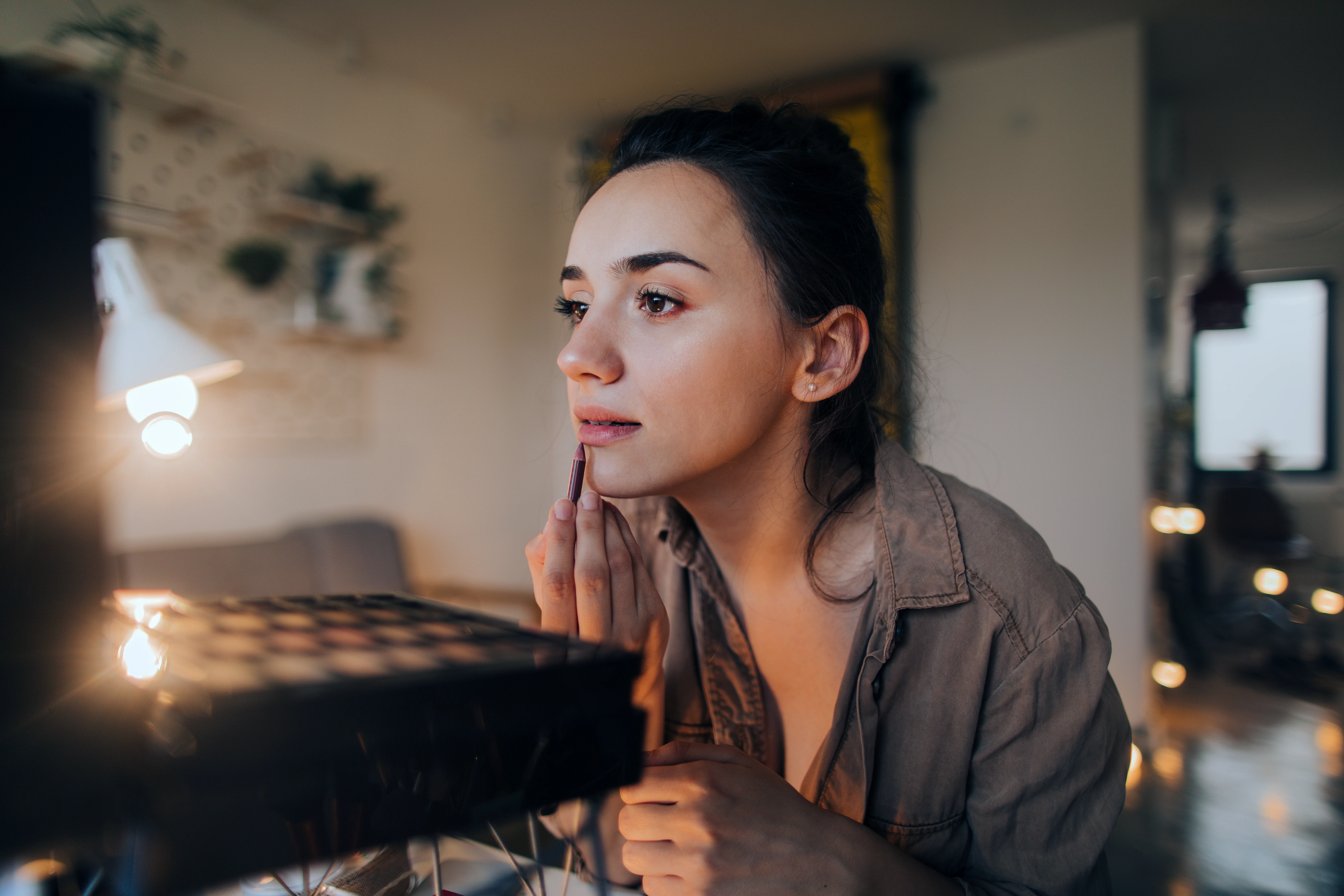 Tjej som sminkar sig, en del sminkprodukter kan orsaka perioral dermatit.