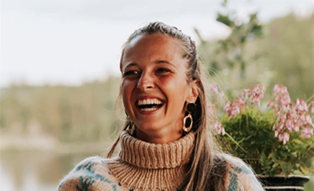 En person som skrattar utomhus.