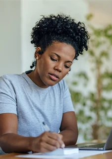 Kvinna som sitter vid en laptop och skattar sitt nikotinberoende efter Fagerströms beroendeskala.