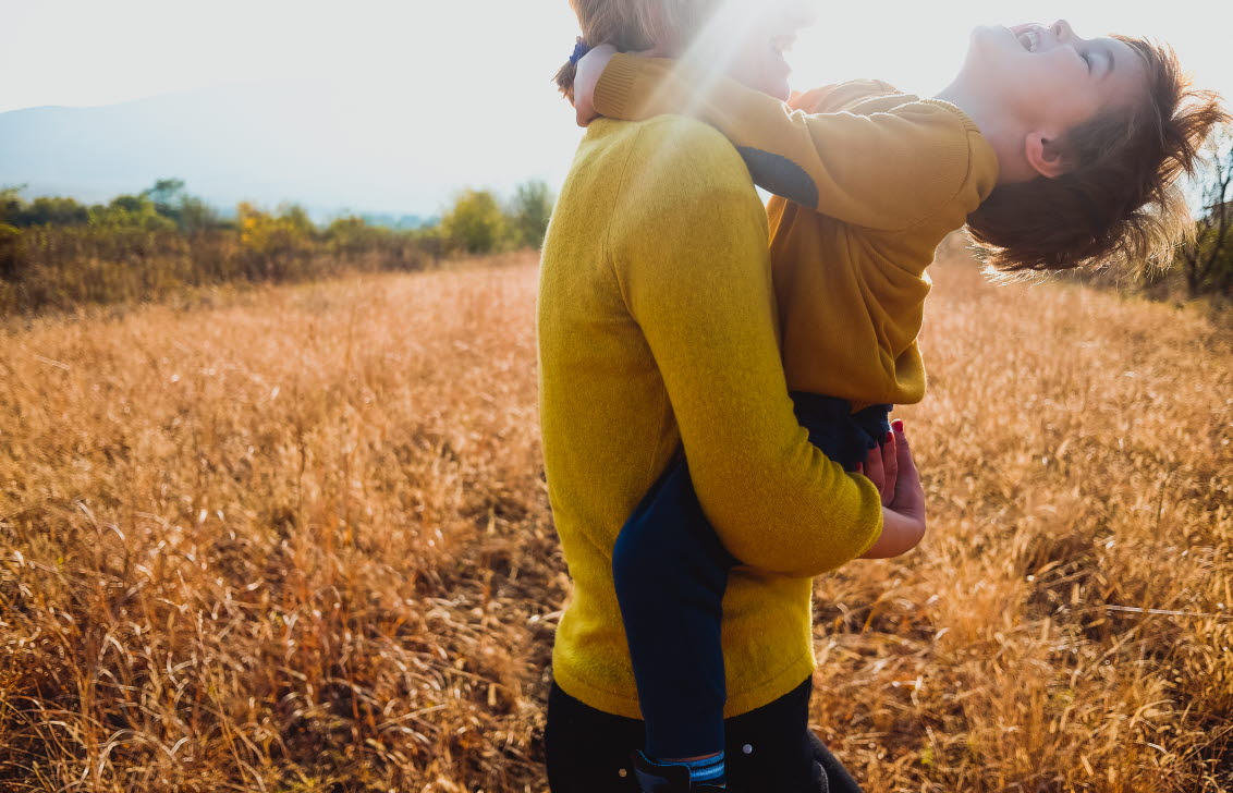 En mamma som lyfter upp sitt barn.