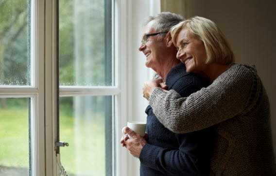 En kvinna kramar om en man bakifrån.