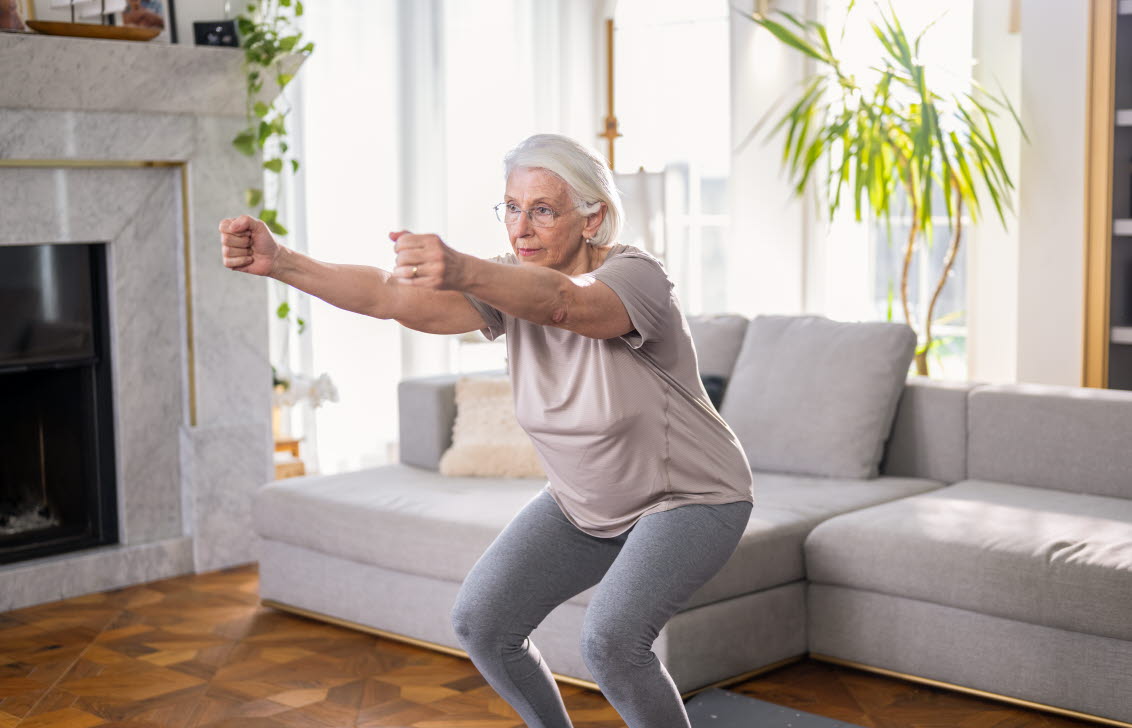 En kvinna gör lätta knäböj för att öva upp balansen.