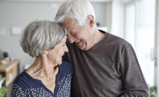 En äldre man och kvinna som håller om varandra.