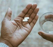 Två tabletter i en handflata.