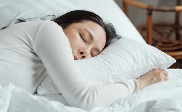 En kvinna sover i sin säng.