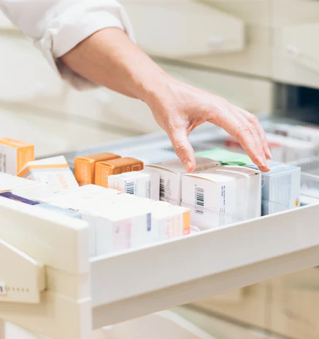 Farmaceut som plockar ett GLP-1 läkemedel.