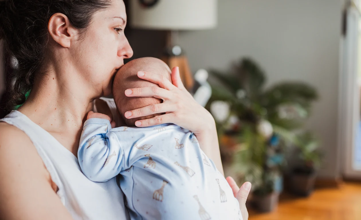 Bebis som har kolik och besväras av ont i magen får tröst av sin mamma.