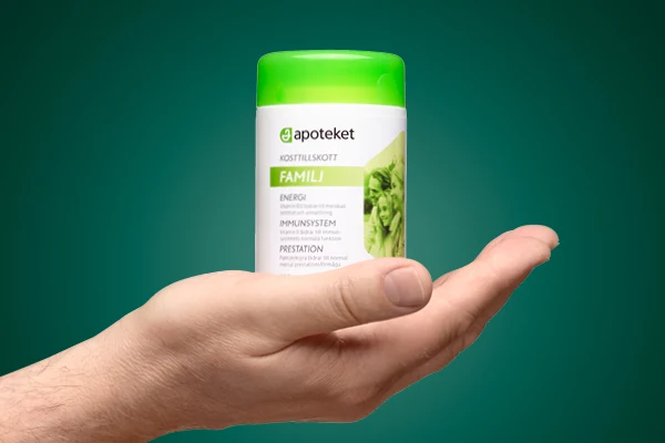 en hand som håller i ett kosttillskott från apoteket.