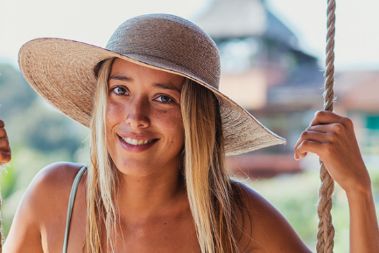 Tjej med känslig hud i solen.