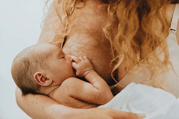 En mamma som ammar sin bebis.