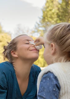 Dotter som torkar sin mammas näsa.