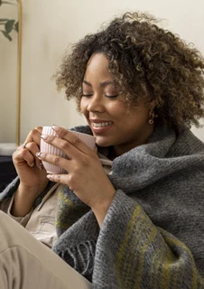 Kvinna som vilar och dricker te för att bli frisk snabbare.